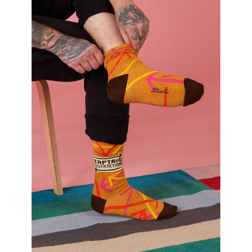 A colorful pair of Blue Q socks featuring the phrase 'Captain Distraction' with fun superhero-style graphics, perfect for easily distracted but lovable personalities.