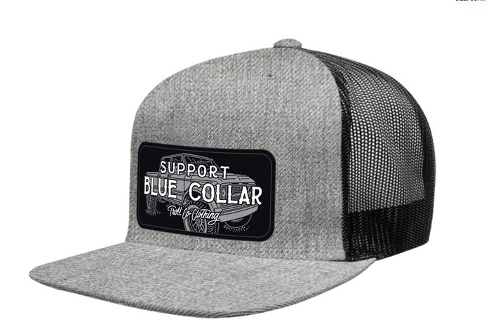 Introducing the SBC Barricade Truckin Flat Brim Trucker in heather gray and black, featuring a flat brim snapback design with a patch that reads “Support Blue Collar Full Clothing Co” and showcases an illustrated pickup truck in the background.