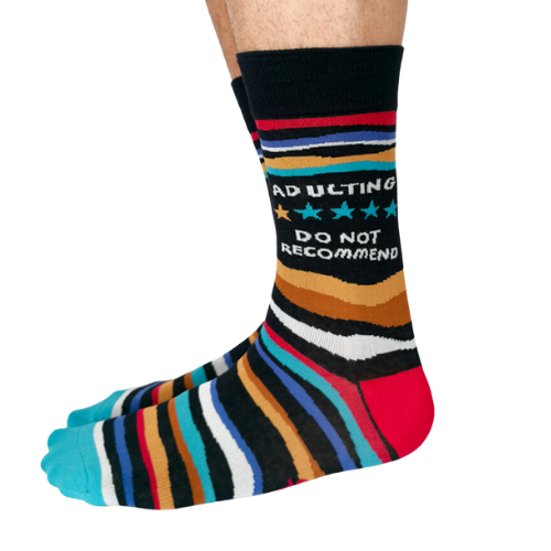 A close-up of Uptown Sox's Adulting Socks featuring funny illustrations and phrases about the challenges of adult life, perfect for anyone who can relate to the ups and downs of growing up.