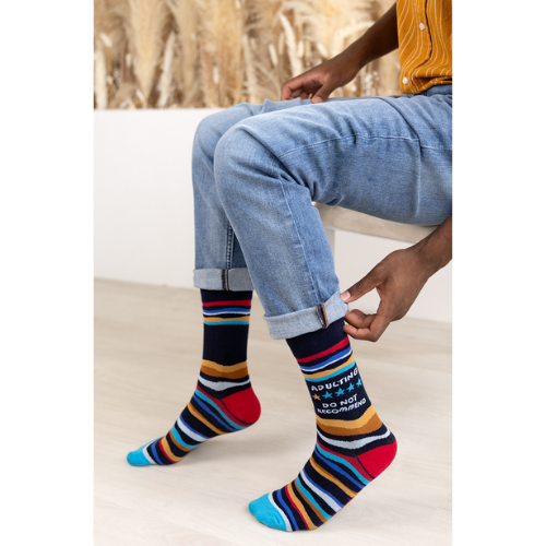 A close-up of Uptown Sox's Adulting Socks featuring funny illustrations and phrases about the challenges of adult life, perfect for anyone who can relate to the ups and downs of growing up.