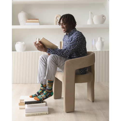 Pair of men's crew socks in orange, green, and black with a bookshelf design and the phrase 'I Like Big Books and I Cannot Lie' displayed on the side.
