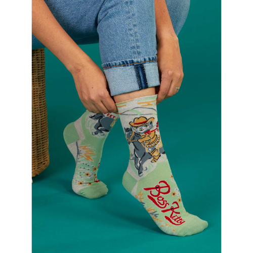 A pair of Blue Q socks featuring a confident cartoon cat with the phrase "Boss Kitty," designed with fun colors and a sassy vibe for strong, independent personalities.