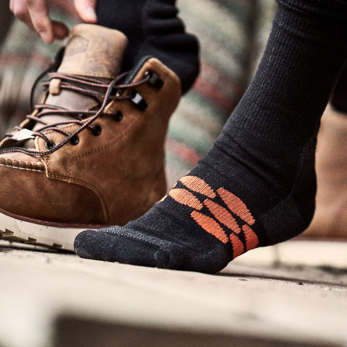 Everyday crew work socks by BRUNT in black, shown worn in a lifestyle job site setting