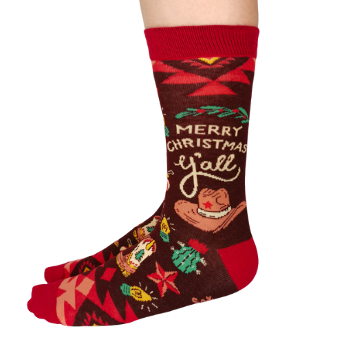 Pair of women's crew socks with a brown and red country Christmas design, featuring cowboy hats, cacti, and the phrase 'Merry Christmas Y'all' in festive holiday colors.