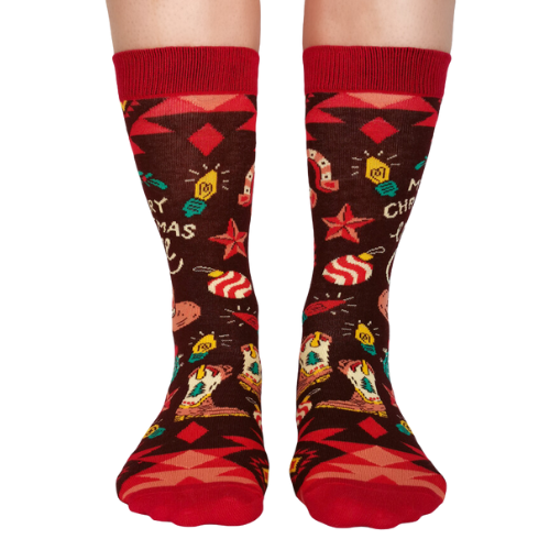 Pair of women's crew socks with a brown and red country Christmas design, featuring cowboy hats, cacti, and the phrase 'Merry Christmas Y'all' in festive holiday colors.