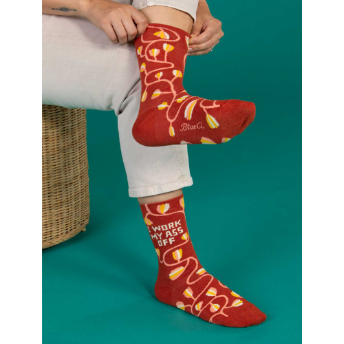 A pair of Blue Q socks with the phrase 'I Work My Ass Off' in bold letters, featuring a fun, colorful design for hardworking personalities.