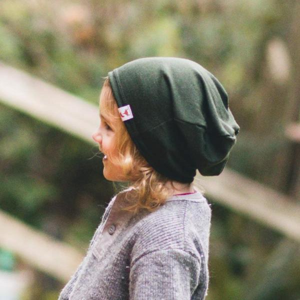 Child side profile head shot wearing a dark green merino wool slouchie hat made by TK Clothing