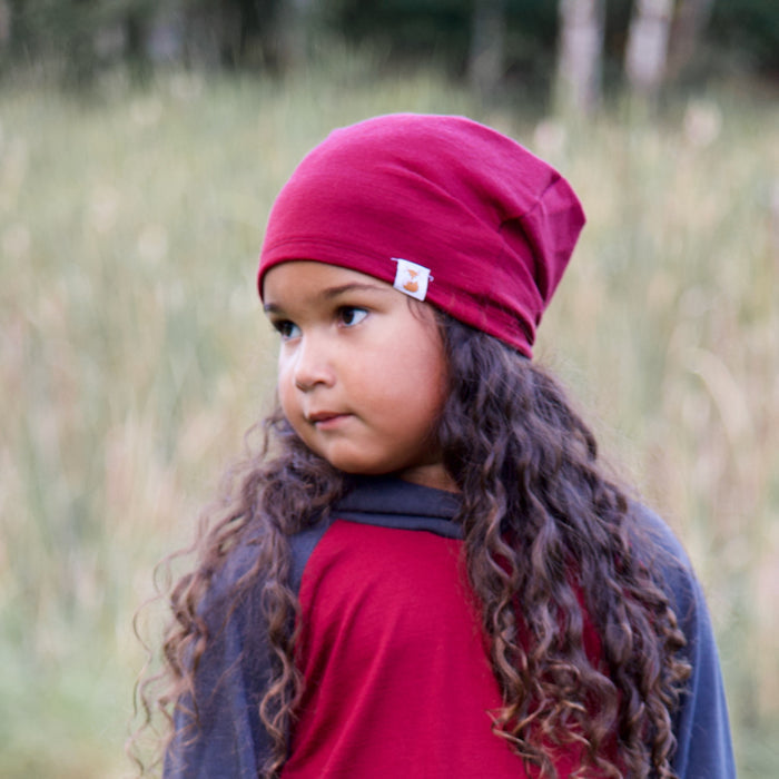 Child wearing a darker pink merino wool slouchie hat made by TK Clothing