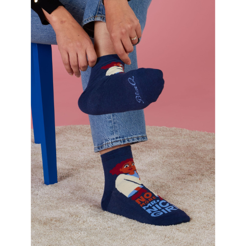A pair of fierce Blue Q socks featuring the phrase 'No More Mr. Nice Girl' in bold lettering with stylish, empowering graphics.