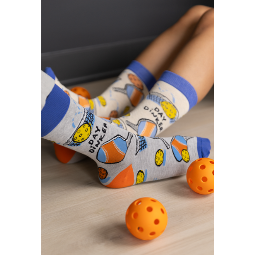 Pickleball-themed socks with vibrant patterns, perfect for players, featuring paddles and balls from Uptown Sox.
