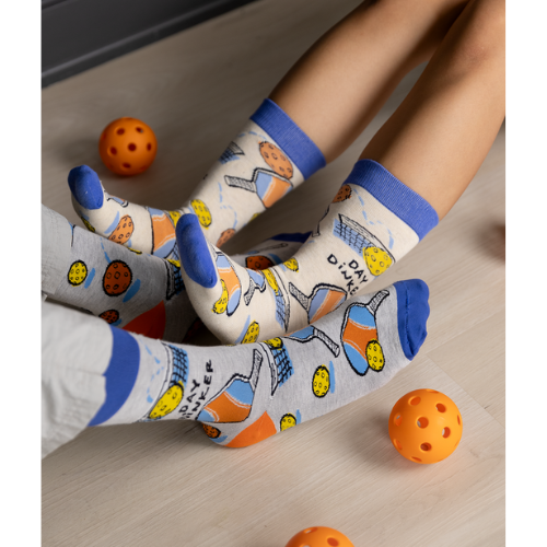Gray Day Dinker socks featuring colorful pickleball paddles, balls, and nets with a blue cuff and toe design
