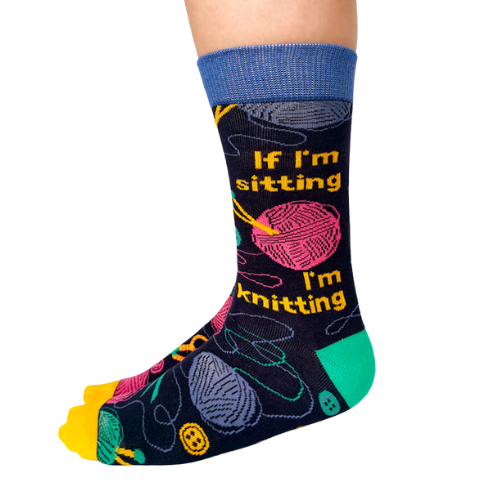 Women's crew socks with colorful knitting-themed designs, featuring the text 'If I’m sitting, I’m knitting.