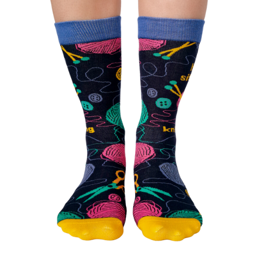 Women's crew socks with colorful knitting-themed designs, featuring the text 'If I’m sitting, I’m knitting.