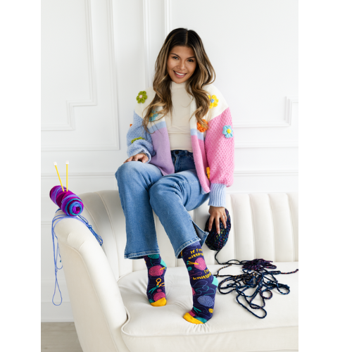 Women's crew socks with colorful knitting-themed designs, featuring the text 'If I’m sitting, I’m knitting.
